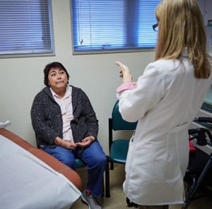 Older female patient listens to doctor